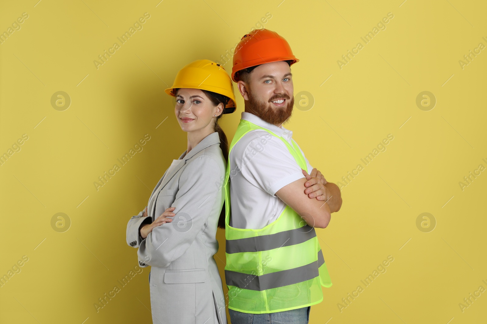 Photo of Engineers in hard hats on yellow background