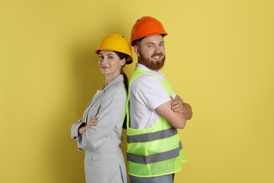 Engineers in hard hats on yellow background