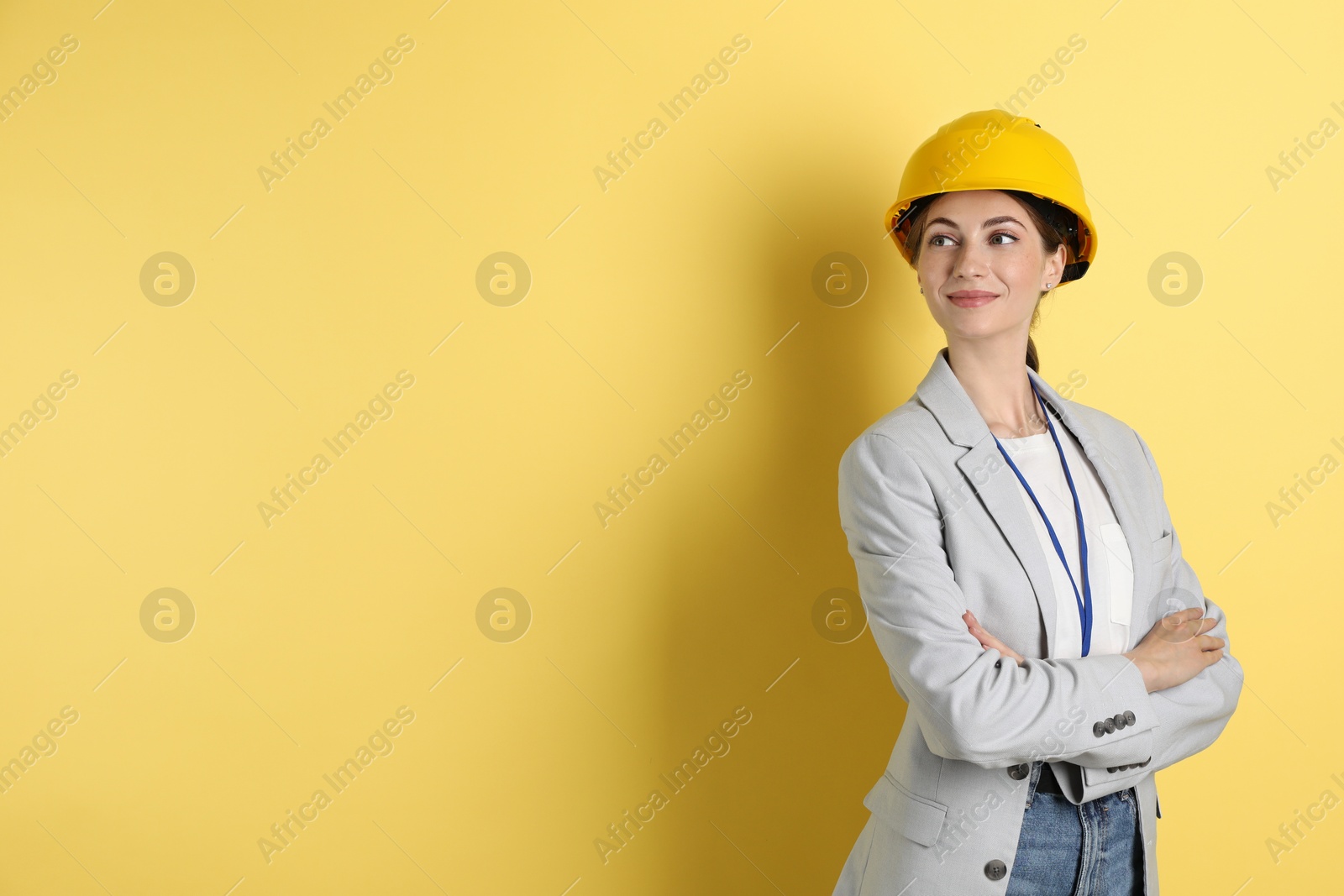 Photo of Engineer in hard hat on yellow background, space for text