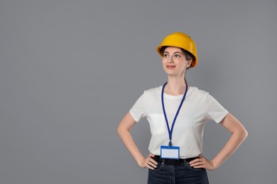 Engineer in hard hat on grey background, space for text