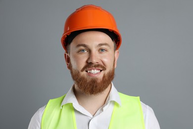 Engineer in hard hat on grey background