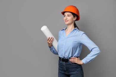 Engineer in hard hat with draft on grey background, space for text