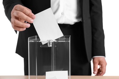 Photo of Man putting his vote into ballot box at table against white background, closeup