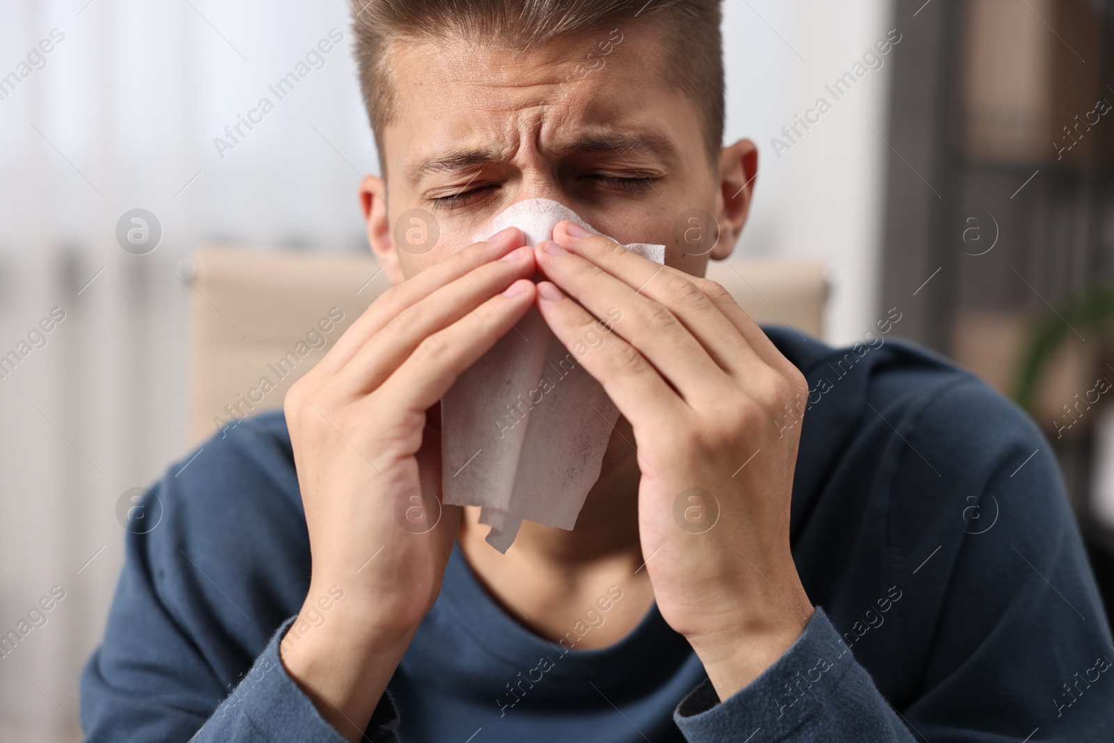 Photo of Young man with tissue suffering from sinusitis indoors