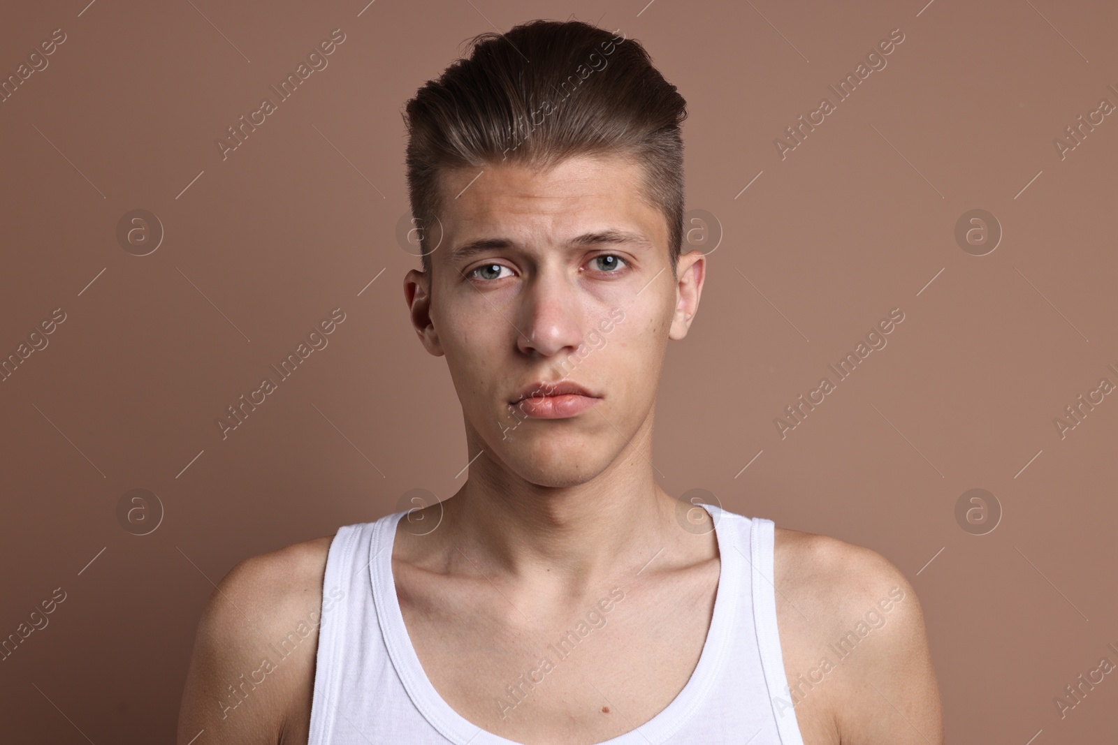 Photo of Portrait of handsome young man on light brown background