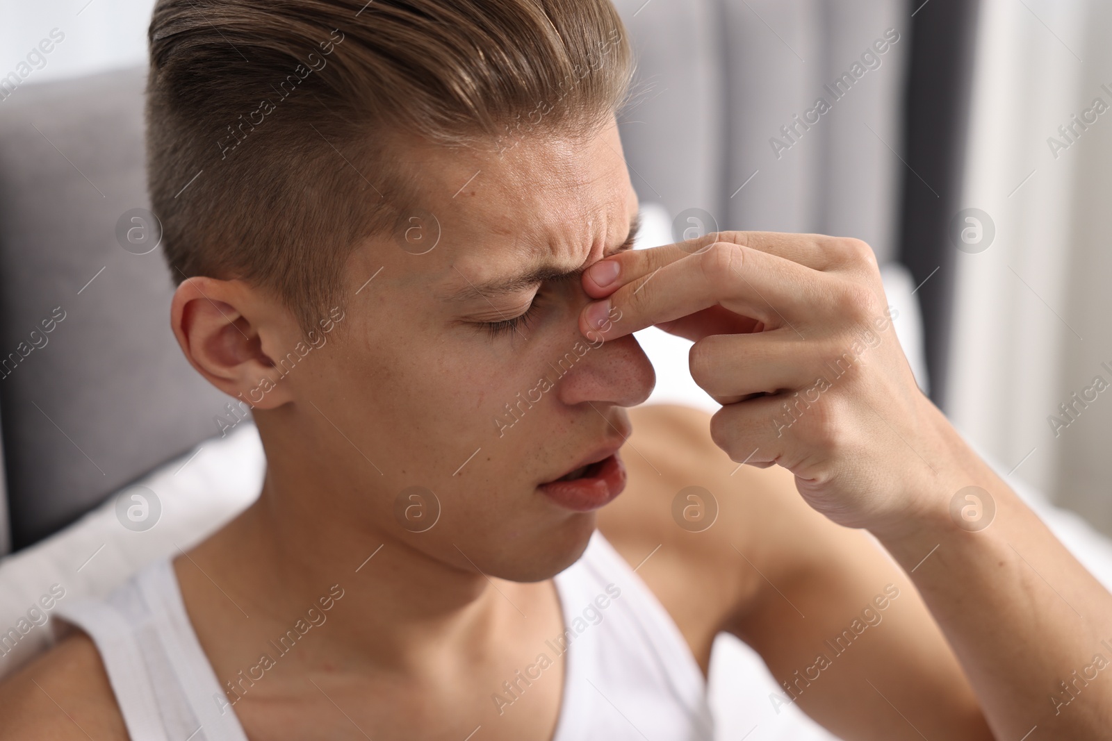 Photo of Young man suffering from sinusitis at home