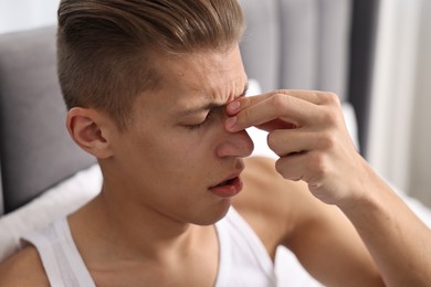 Young man suffering from sinusitis at home