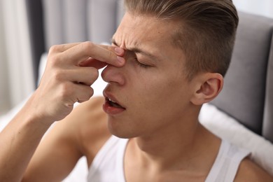 Young man suffering from sinusitis at home