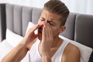 Young man suffering from sinusitis at home