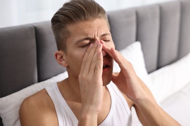 Young man suffering from sinusitis at home