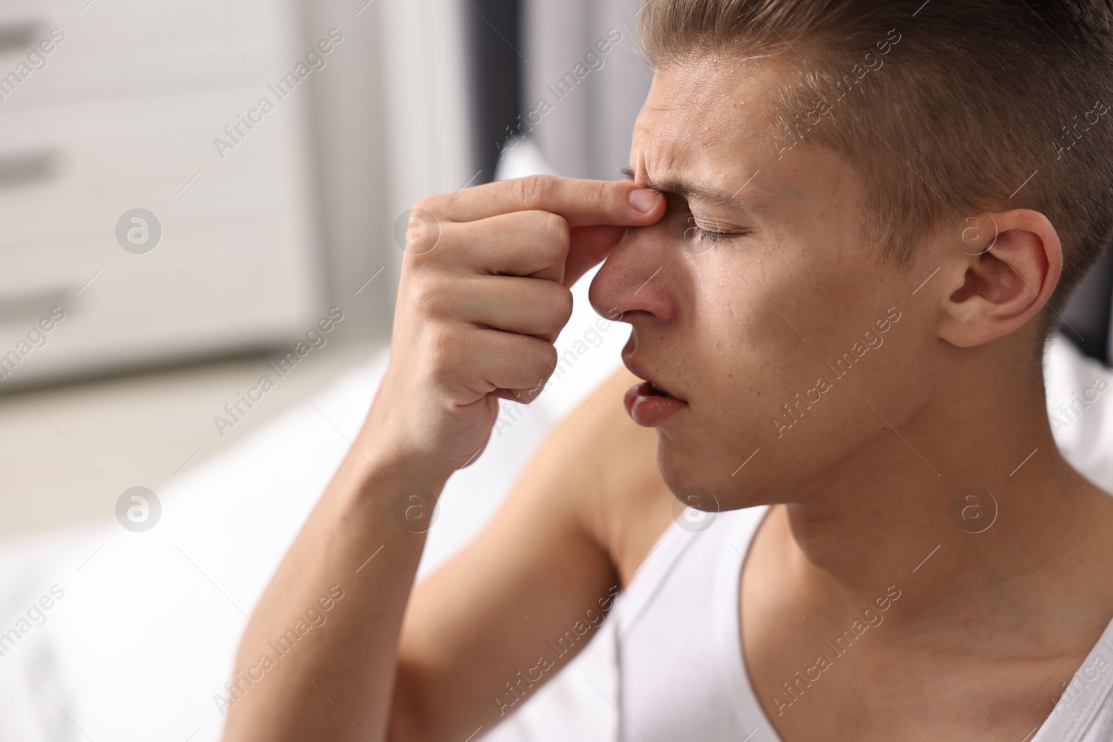 Photo of Young man suffering from sinusitis at home