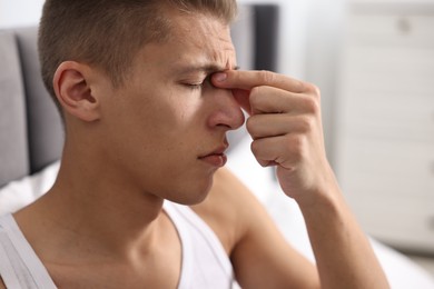 Photo of Young man suffering from sinusitis at home