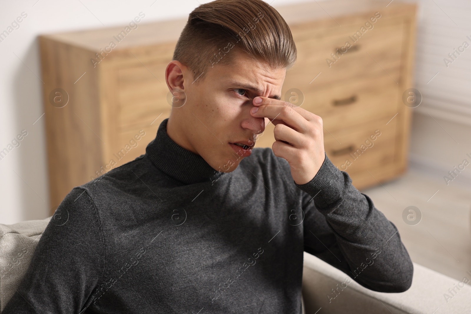 Photo of Young man suffering from sinusitis at home