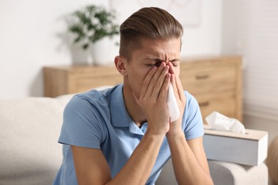 Photo of Young man with tissue suffering from sinusitis at home