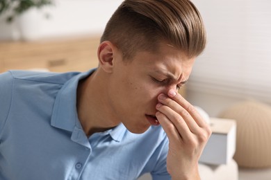 Young man suffering from sinusitis at home