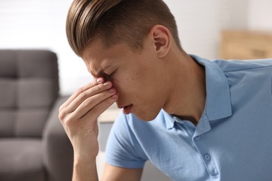 Young man suffering from sinusitis at home