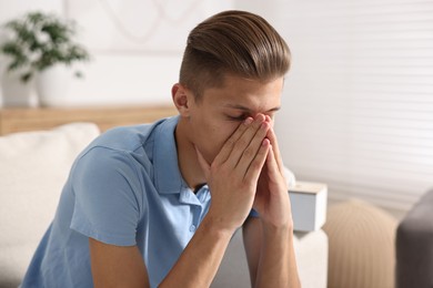 Young man suffering from sinusitis at home