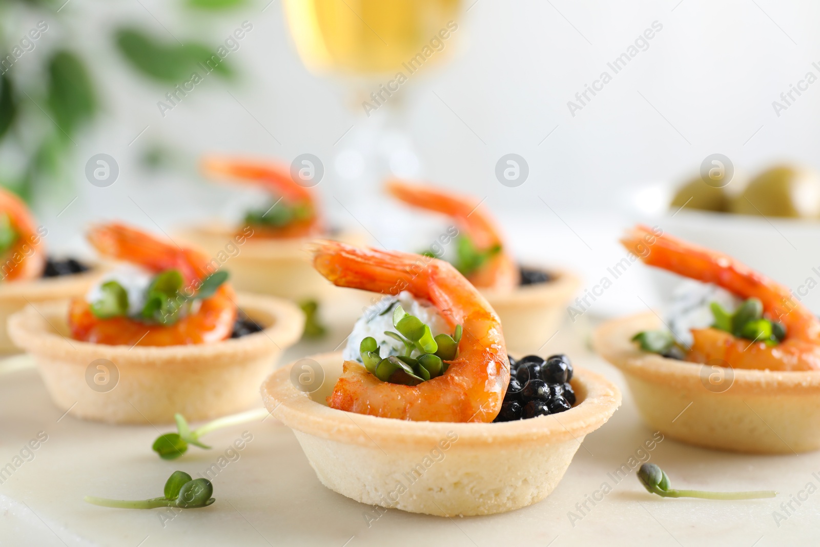 Photo of Delicious canapes with shrimps and black caviar on table, closeup