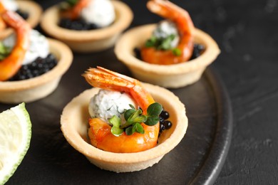 Photo of Delicious canapes with shrimps and black caviar on table, closeup