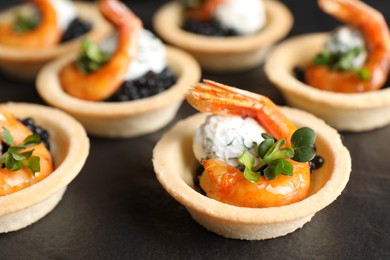 Photo of Delicious canapes with shrimps and black caviar on table, closeup