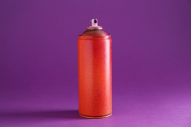 Photo of One spray paint can on violet background