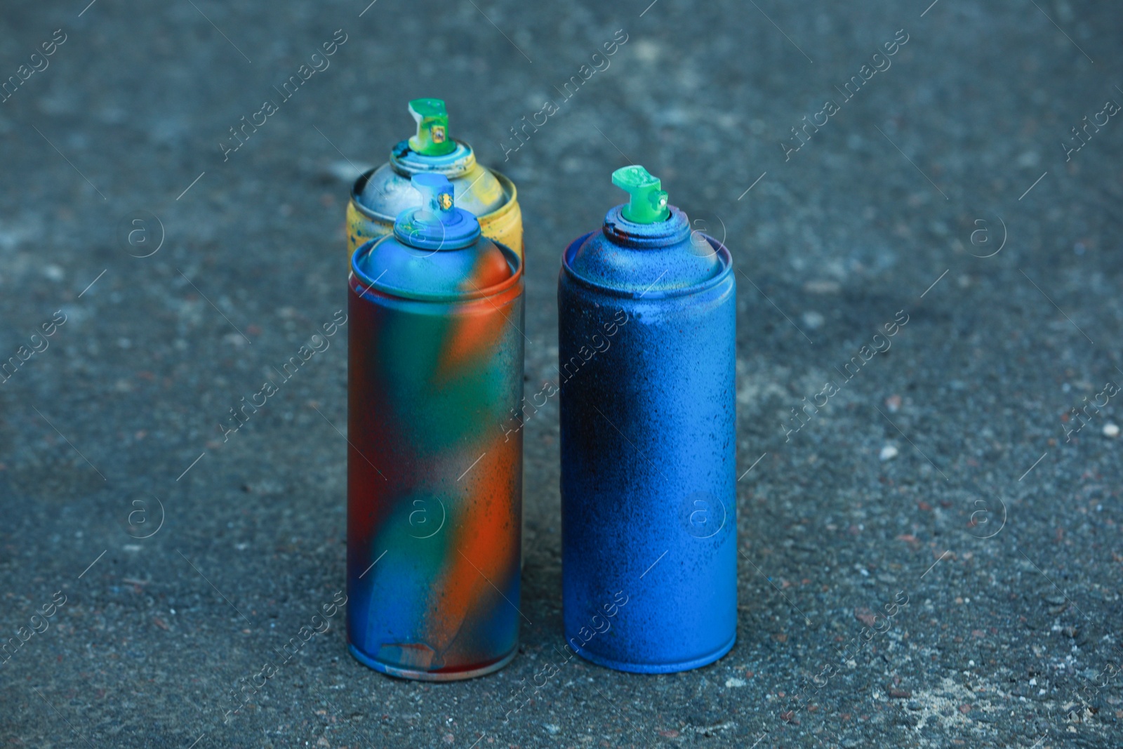 Photo of Many spray paint cans on ground outdoors