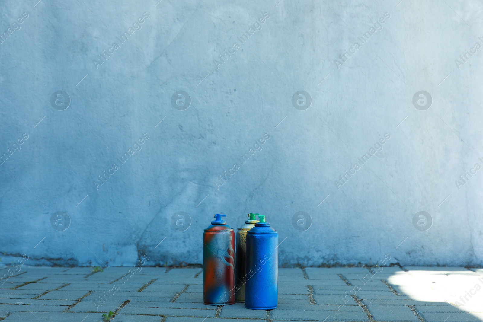 Photo of Many spray paint cans outdoors, space for text