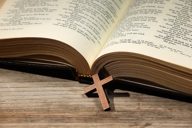 Bible and cross on wooden table, closeup. Religion of Christianity