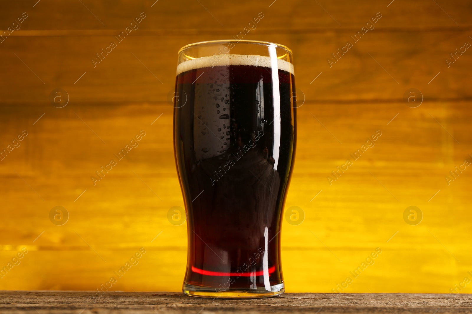 Photo of Glass of cold beer on wooden table