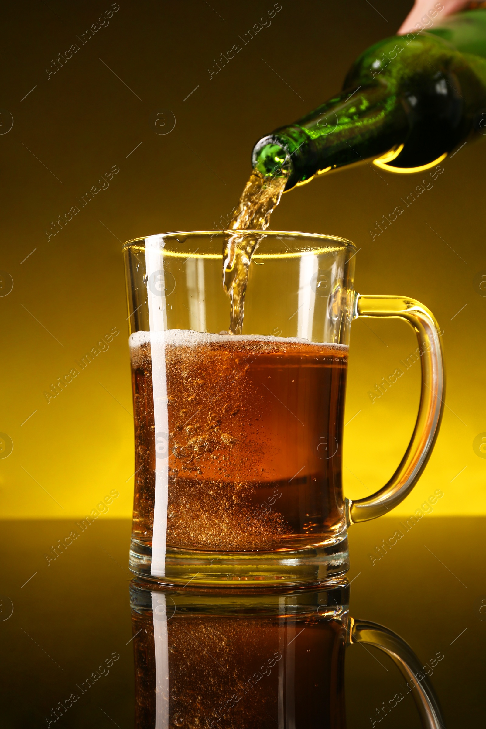 Photo of Man pouring beer into glass mug from bottle on dark table, closeup