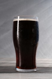 Photo of Glass of beer on grey wooden table