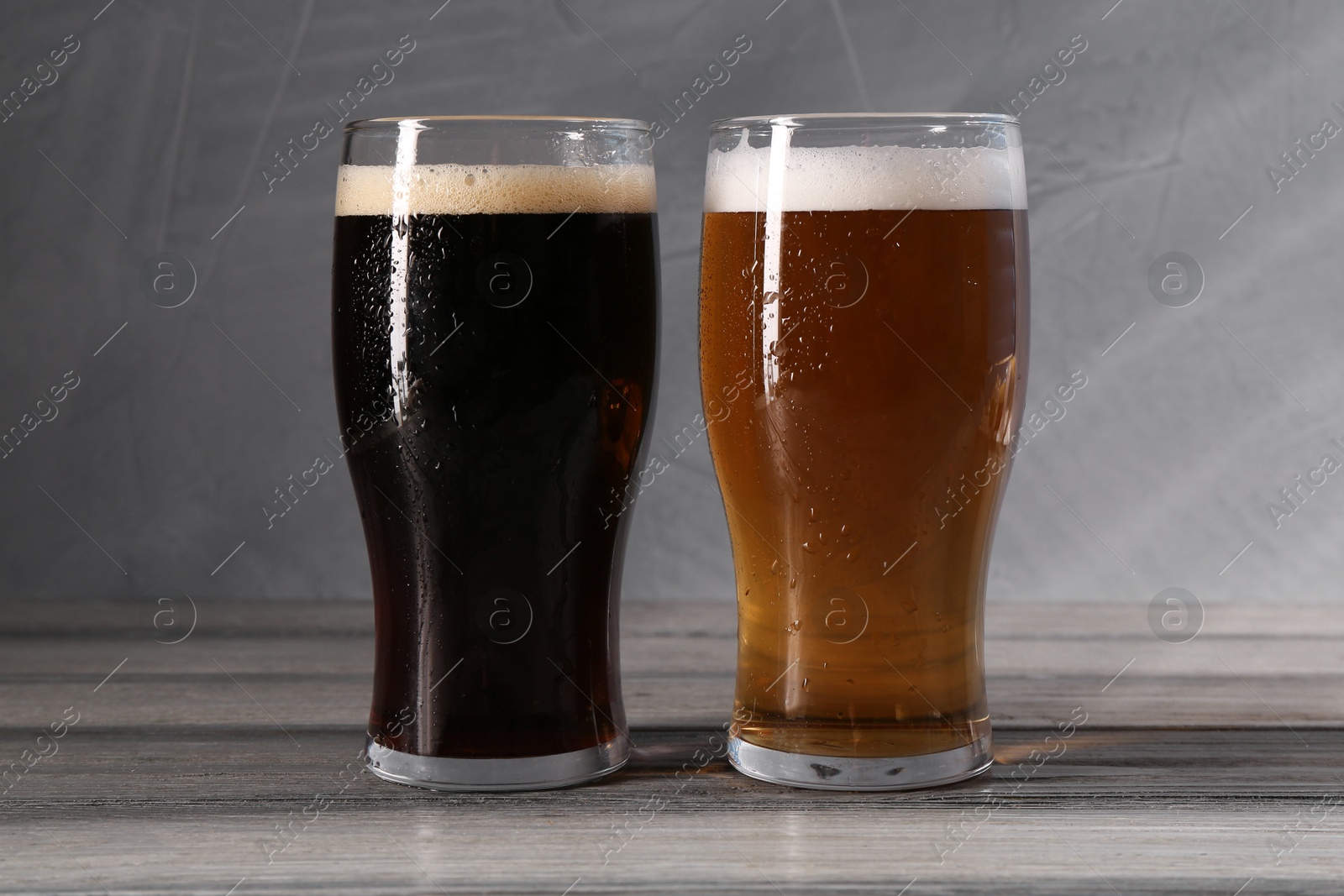 Photo of Glasses with different types of beer on grey wooden table