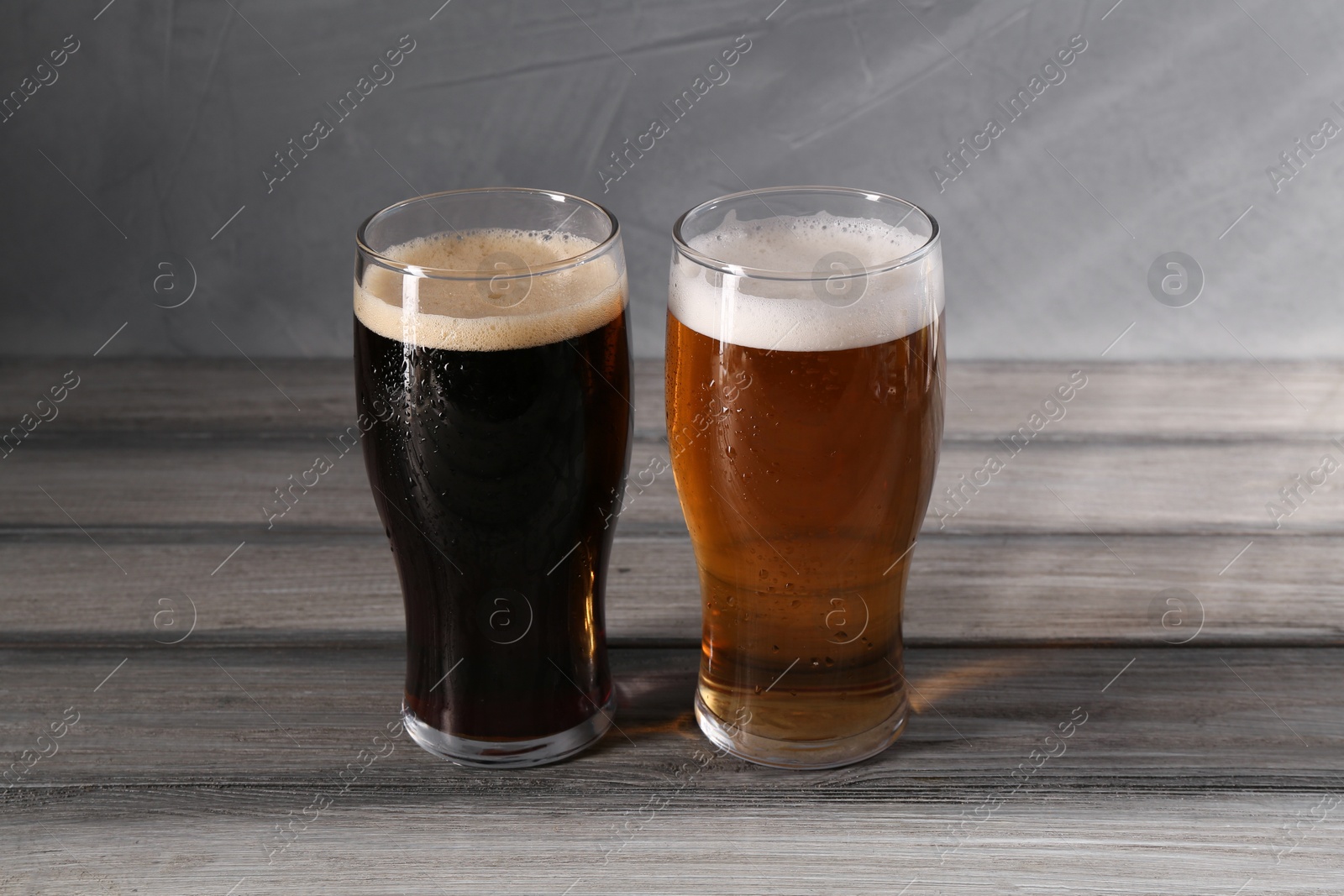 Photo of Glasses with different types of beer on grey wooden table