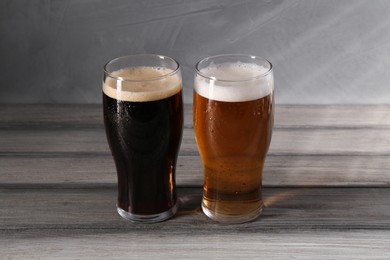 Photo of Glasses with different types of beer on grey wooden table