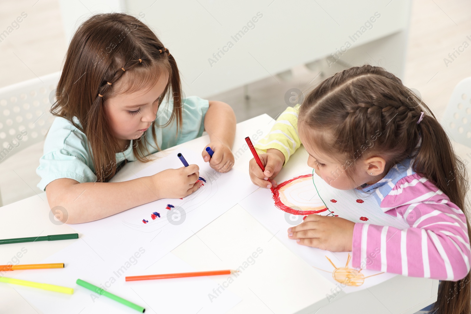 Photo of Cute little children drawing at table indoors