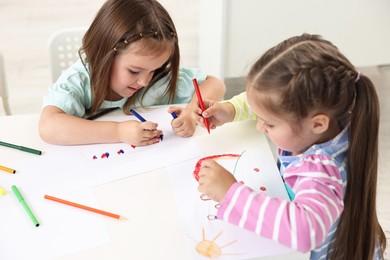 Cute little children drawing at table indoors