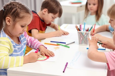 Group of children drawing at table indoors