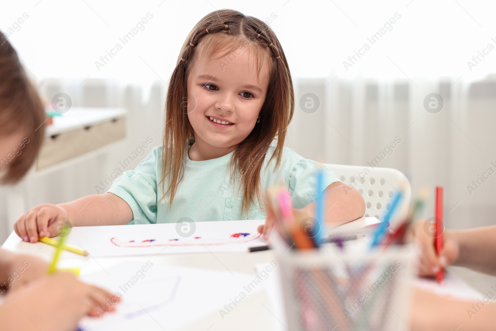 Photo of Cute little children drawing at table indoors