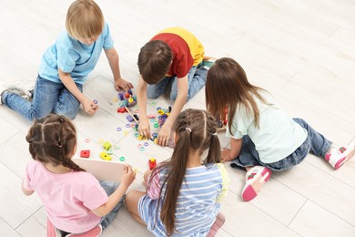 Photo of Group of children playing together on floor indoors