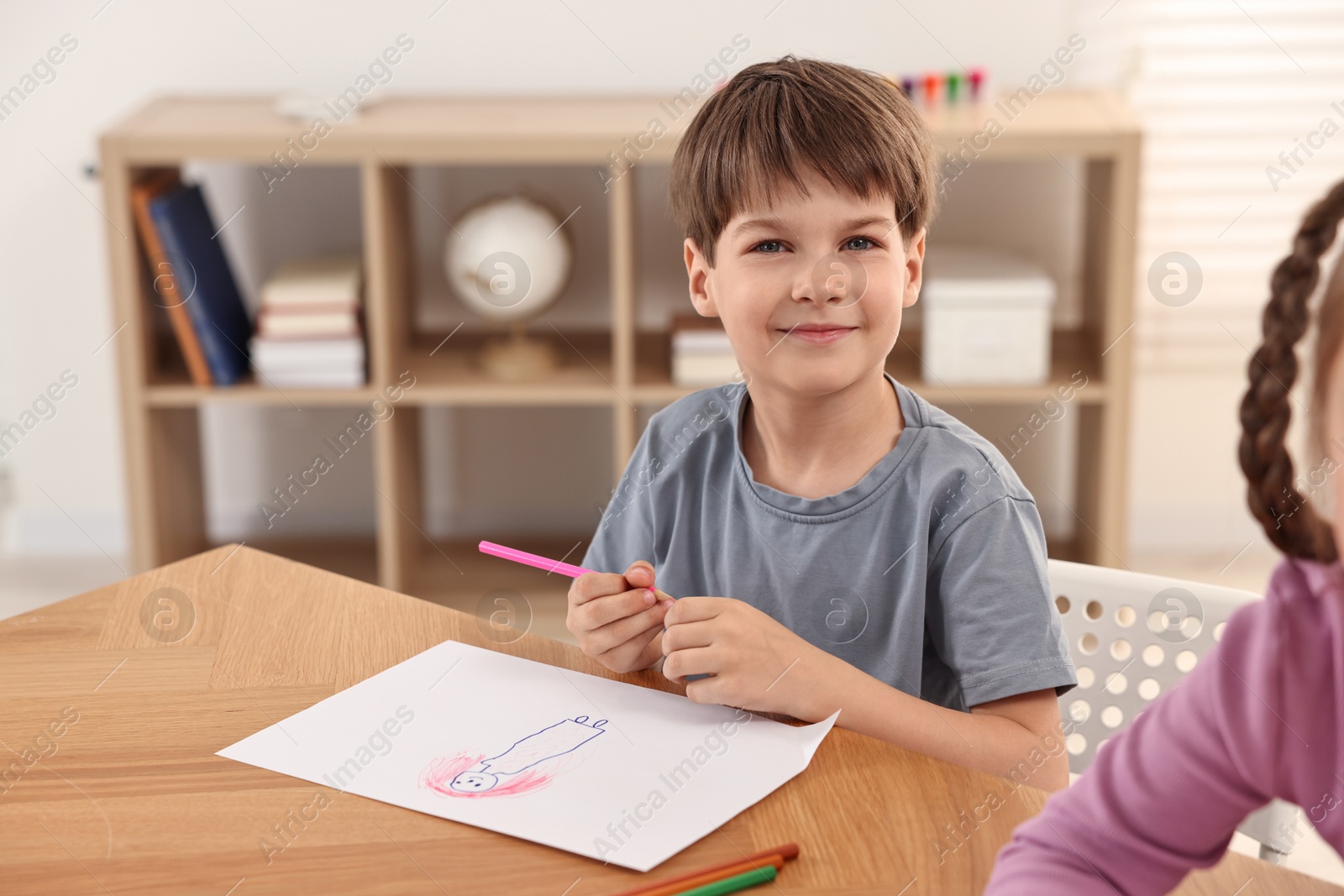 Photo of Cute little children drawing at wooden table indoors