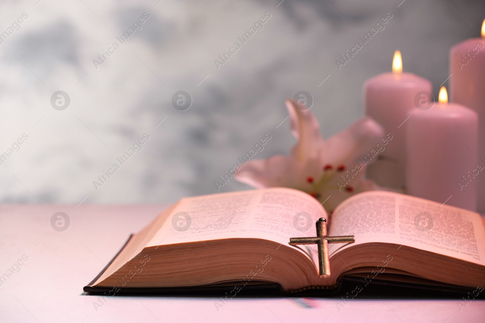 Photo of Cross, Bible, flower and burning candles on light table, closeup with space for text. Religion of Christianity