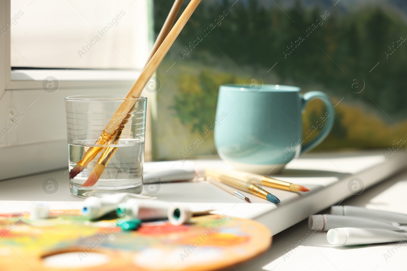 Photo of Artist's palette, brushes and paints on window sill