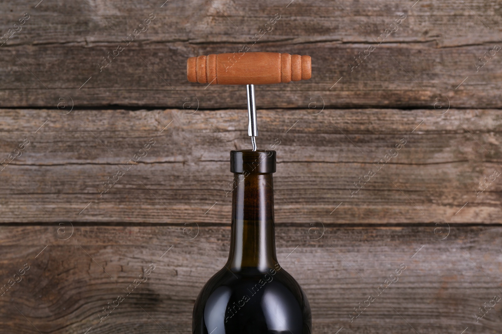 Photo of Wine bottle with corkscrew on wooden background