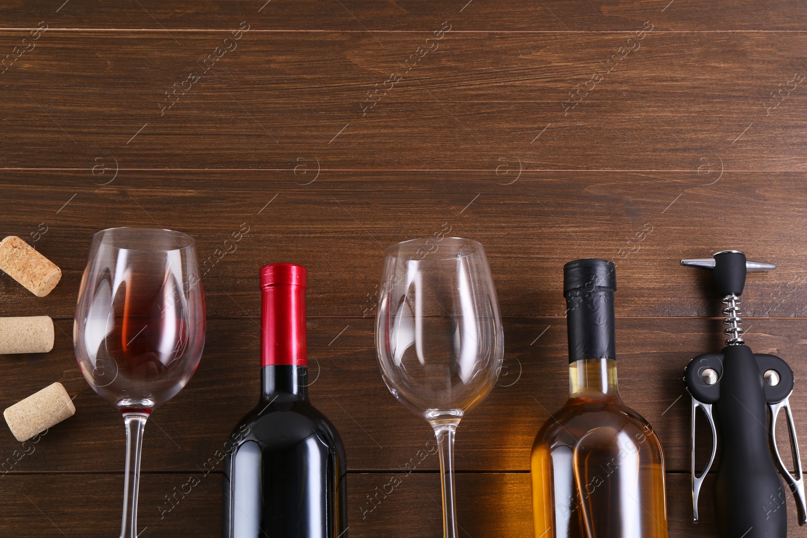 Photo of Flat lay composition with wing corkscrew and wine on wooden table. Space for text