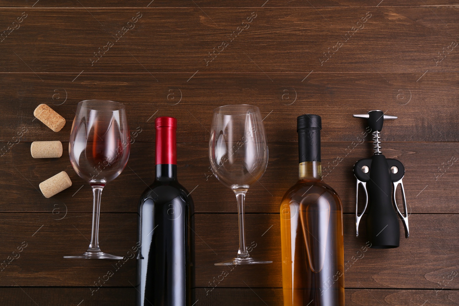 Photo of Flat lay composition with wing corkscrew and wine on wooden table