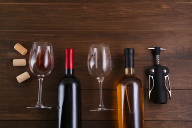 Photo of Flat lay composition with wing corkscrew and wine on wooden table