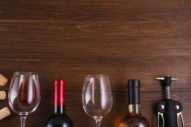 Photo of Flat lay composition with wing corkscrew and wine on wooden table. Space for text