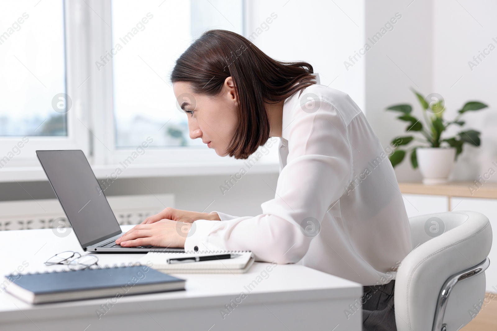 Photo of Woman with poor posture working in office