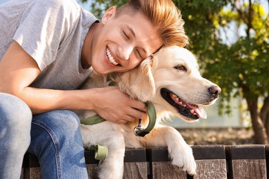 Photo of Portrait of happy owner with cute Golden Retriever dog outdoors on sunny day