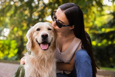 Photo of Owner kissing her cute Golden Retriever dog outdoors